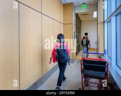 Passagers marchant le long du couloir dans la zone de départ de l'aéroport. Banque D'Images