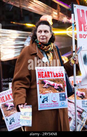 Manifestation contre la fourrure des droits des animaux devant Harvey Nichols Londres 30 novembre 2013 - dame âgée en long manteau brun portant le signe sans cœur Harvey Nichols Banque D'Images