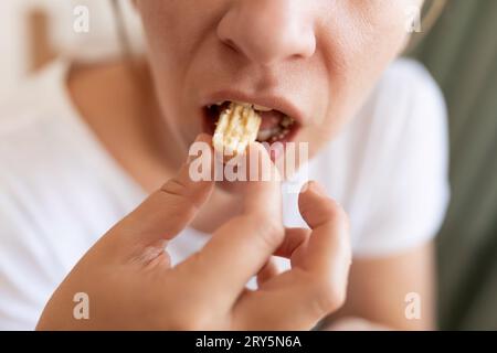 jeune femme grignotant sur la malbouffe sucrée avec des gras trans Banque D'Images