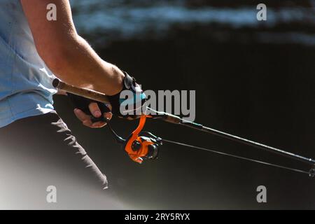 Chasse à la pêche. Pêcheur ne coulent par la canne à filer de baitcasting au lac pour brochet. Banque D'Images