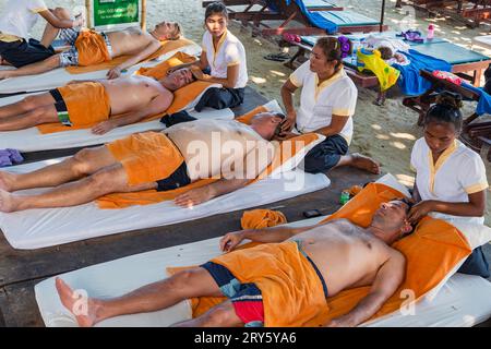 Dames donnant massage thaï traditionnel sur la plage de Chaweng, Ko Samui, Thaïlande Banque D'Images