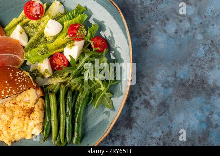 salade d'été diététique avec fromage, asperges, cerise, roquette sur fond gris-bleu. Vue de dessus. espace de copie. service de restaurant Banque D'Images