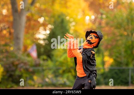 Jeune enfant pose dans un costume effrayant de citrouille Halloween. Banque D'Images