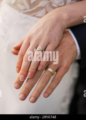 Les mains de la mariée et du marié avec des anneaux de mariage en or Banque D'Images