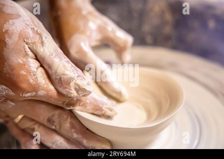 Leçon de poterie. Élève et professeur tout en sculptant sur une roue de potier Banque D'Images