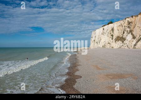 La plage et la falaise de Mers-les-bains, Picardie, France ; surfeur dans la mer. Banque D'Images