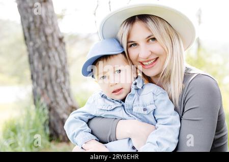 Mère enceinte et son petit fils marchant et s'embrassant dans la forêt et passant du temps amusant ensemble Banque D'Images