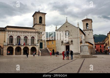 Norcia, Ombrie, Italie. Place San Benedetto, sur la droite l'église de St. Benedict ou San Benedetto, détruit par un tremblement de terre en 2016. Banque D'Images