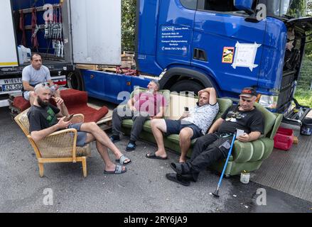 29 septembre 2023, Hesse, Gräfenhausen : les chauffeurs de camions d'Ouzbékistan et de Géorgie sont assis à l'ombre de leurs véhicules à l'arrêt Gräfenhausen sur l'A5 en Hesse. Les camionneurs attendent le paiement de leur salaire depuis plus de deux mois. Photo : Boris Roessler/dpa Banque D'Images