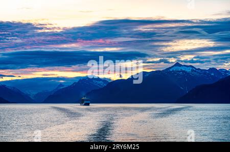 Croisière vers le sud depuis Skagway, Alaska, au crépuscule. Un bateau de croisière, Royal Princess, peut être vu au loin. Banque D'Images
