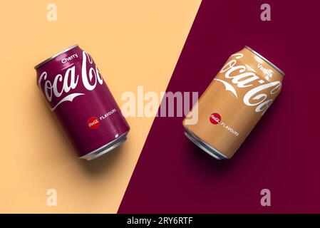 Gros plan de canettes de cerise Coca Cola et de vanille Coca Cola sur fond jaune et rouge Banque D'Images