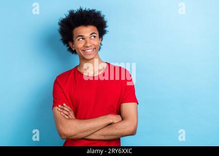 Portrait d'un étudiant multinational drôle croisant les mains personne confiante regarder l'espace vide ad annonces isolé fond de couleur bleue Banque D'Images