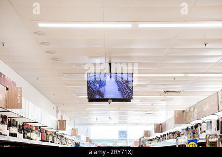 Écran de surveillance par reconnaissance faciale suspendu au plafond dans l'allée commerciale du supermarché Tesco Banque D'Images