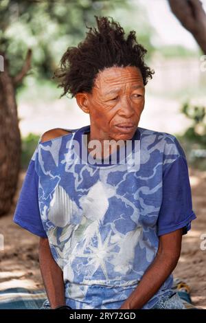 Un vieux bushmen san Woman du Kalahari central, village de New Xade au Botswana, dans la cour de la maison après la relocalisation Banque D'Images
