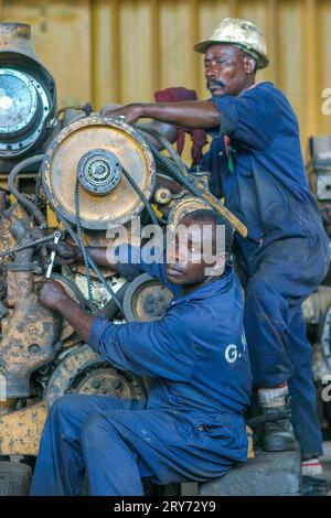 Ghana, Takoradi. Les mécaniciens de la société minière de manganèse réparent un moteur dans l'atelier. Banque D'Images