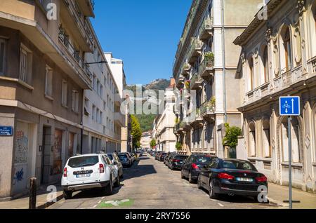 La rue Dominique Villars donne sur les montagnes au bout de Grenoble, France Banque D'Images