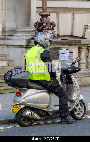 Pilote de scooter moteur étudiant la carte avec des emplacements détaillés, éventuellement faire «la connaissance» dans la formation pour être un chauffeur de taxi à Londres, Royaume-Uni. Apprenti Banque D'Images