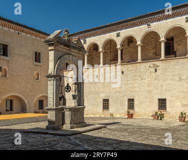 Le cloître, la loggia du XVIe siècle et la place médiévale avec le puits monumental dans le sanctuaire de San Matteo l'Apôtre. Puglia Banque D'Images