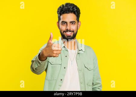 J'aime. L'homme indien soulève les pouces vers le haut est d'accord avec quelque chose ou donne une réponse positive recommande la publicité aime la rétroaction de bonne idée, célébrant la victoire de succès. Guy isolé sur fond jaune studio Banque D'Images