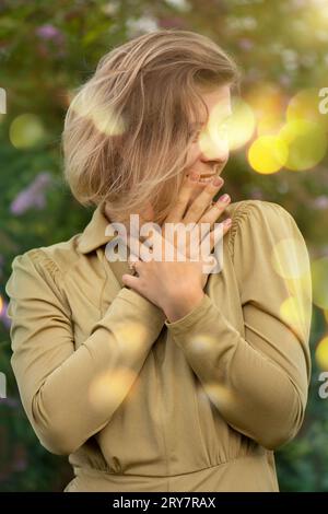 Fille blonde à l'extérieur dans le buisson papillon ou lilas d'été. Buddleia fleurs et élégante jeune femme. Banque D'Images