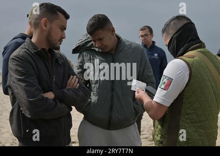 Tijuana, Basse-Californie, Mexique. 28 septembre 2023. Les migrants de la nation africaine de Mauritanie sont arrêtés alors que les officiers de l’immigration mexicaine ainsi que les unités militaires de la garde nationale et des marines patrouillent et vérifient les cartes d’identité des spectateurs le jeudi 28 septembre 2023. Au cours des derniers jours, de nombreux migrants ont traversé le chantier par de petits groupes, des couples et des célibataires risquant d'être capturés par les autorités américaines et mexicaines, alors qu'une vidéo virale sur les médias sociaux a attiré l'attention des autorités frontalières sur une hausse des passages dans la région, comme gat temporaire Banque D'Images