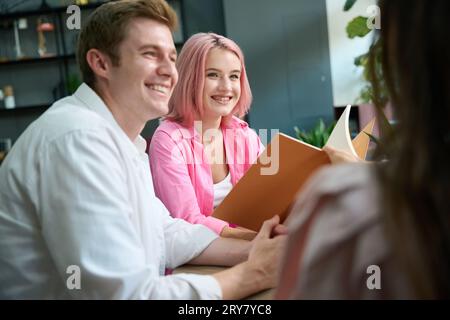 Les acheteurs communiquent avec le gestionnaire et regardent les catalogues, ils sont situés à la table Banque D'Images