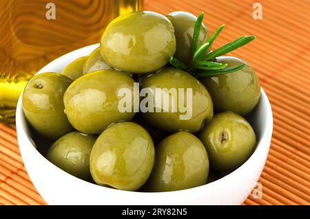 Olives vertes dans un bol en céramique blanche Banque D'Images