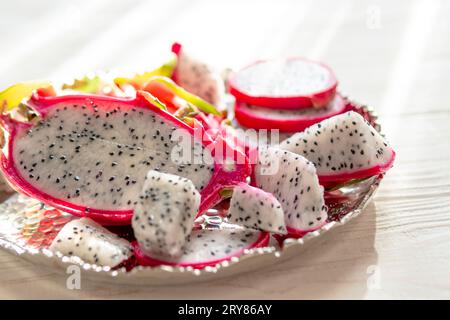 Tranches de pitaya blanc frais ou fruit du dragon sur fond en bois, vue de dessus. Concept de nourriture exotique tropicale et végétalienne. Banque D'Images