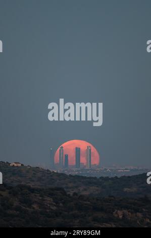 Madrid, Espagne. 29 septembre 2023. La pleine superlune de septembre, connue sous le nom de la Lune des moissons, se lève au-dessus de la ligne d'horizon avec les gratte-ciel de la zone d'affaires four Towers de Madrid marquant la quatrième et dernière superlune de 2023. Crédit : Marcos del Mazo/Alamy Live News Banque D'Images