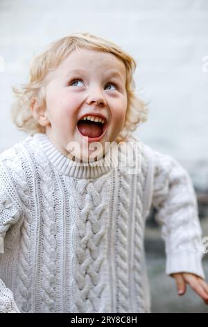 Portrait de Happy Blonde Girl riant et regardant vers le haut Banque D'Images