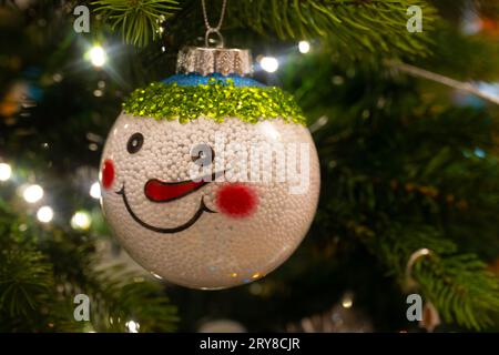 Gros plan d'une décoration de Noël de bonhomme de neige accrochée à l'arbre de Noël Banque D'Images