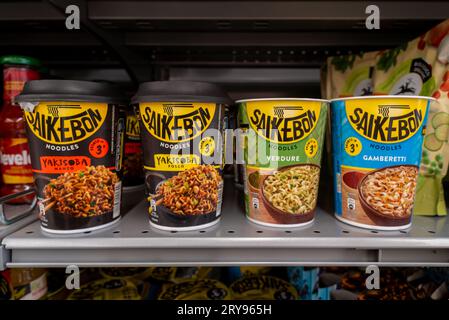 Italie - 29 juillet 2023 : Star Saikebon nouilles pré-cuites de diverses saveurs et garnitures dans des tasses en carton alimentaire exposées sur des étagères à vendre en italien s Banque D'Images