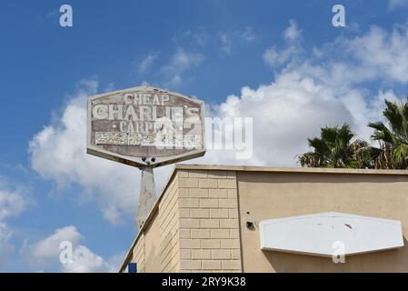 BUENA PARK, CALIFORNIE - 20 SEPTEMBRE 2023 : le signe fané au sommet de Cheap Charlies Carpet sur Lincoln Avenue. Banque D'Images