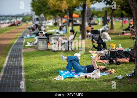 Les gens pique-niquent dans le parc Yeouido sur la rivière Han à Séoul, Corée du Sud, le 23 septembre 2023 Banque D'Images