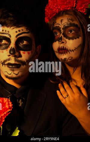 jeune couple habillé comme catrin et catrina posant dans un studio sur un fond, la femme pose sa main sur l'homme Banque D'Images