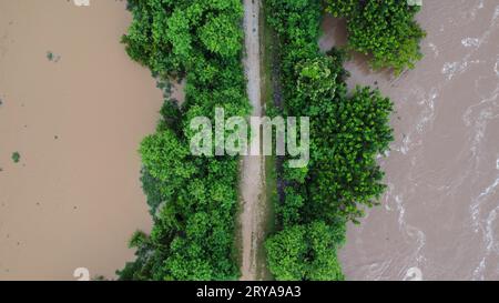 Vue aérienne de la zone touchée par les inondations de la saison des pluies. Vue de dessus d'une rivière qui coule après de fortes pluies et l'inondation des terres agricoles dans le NOR rural Banque D'Images