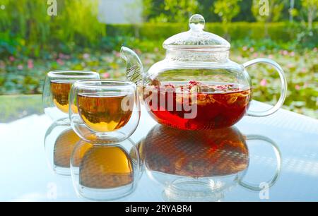 Tasses de thé rose parfumé chaud servi sur la table de jardin Banque D'Images