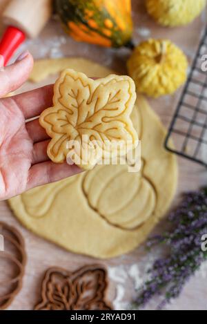 Préparation de biscuits festifs pour la cuisson au four. Biscuits prêts à cuire en forme de feuilles d'automne et de citrouilles. Banque D'Images