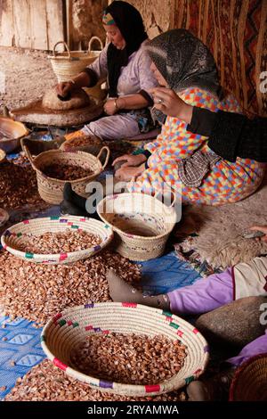 Femmes marocaines fissurant à la main des coquilles de noix dans un village berbère au Maroc Mars 2012 Banque D'Images