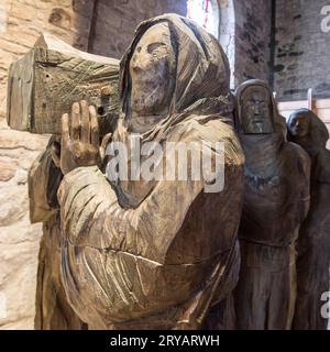 Sculpture massive en bois de moines portant un frère mort dans un cercueil vu à l'église Sainte Marie la Vierge, Lindisfarne. Banque D'Images