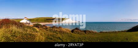 Vue sur les falaises de craie Seven Sisters et les chalets des gardes-côtes de Seaford Head à travers la rivière Cuckmere regardant vers l'est par une journée ensoleillée avec un ciel bleu Banque D'Images