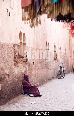 Mendiant de rue portant du Djellaba violet à Marrakech Maroc Mars 2012 Banque D'Images