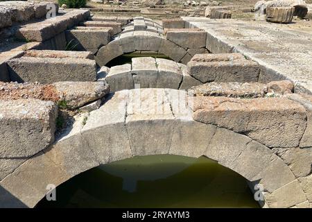 Les ruines de plafond de l'ancien temple en pierre d'Apollon dans la ville antique de Klaros remplissaient l'eau, les arches supérieures et les clés de voûte avec des reflets sous le ciel bleu İzmir Banque D'Images