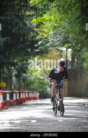 Les cyclistes s'entraînent sur Swains Lane, Highgate, Londres, Royaume-Uni peu de temps avant le début de la campagne cycliste de Londres Urban Hill Climb. L'événement est une course à plat dans la rue la plus escarpée de Londres et à côté des catégories d'âge et de sexe a des compétitions pour les vélos pliants et cargo. Swain’s Lane est la montée la plus célèbre et la plus notoire de Londres. La voie est une section de route extrêmement raide, située entre Hampstead Heath et Highgate Cemetery avec une pente moyenne de 9 % sur 0,6 km, mais augmente à 14 % près du sommet de la montée. Banque D'Images