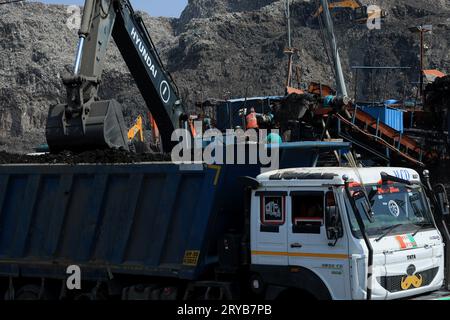 New Delhi, Inde. 30 septembre 2023. Une grue excavatrice JCB remplit le tombereau du site d'enfouissement de Bhalswa à New Delhi. La décharge de Bhalswa est une décharge de déchets surchargée située dans la région du nord-ouest de Delhi. Il mesure plus de 62 mètres (203 pieds) de haut. Le résident local est confronté à la pollution de l'environnement, à des problèmes de santé publique et de sécurité. Crédit : SOPA Images Limited/Alamy Live News Banque D'Images