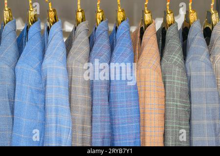 Racks avec différents costumes pour hommes dans une boutique de vêtements pour hommes. Banque D'Images