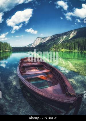 Bateau rouge dans un lac entouré de montagnes Banque D'Images