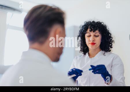 Médecin spécialiste effectuant un examen médical professionnel dans la chambre d'hôpital, vérifiant la pression artérielle, mesurant le sucre dans le sang, et effectuant un hea de l'oreille Banque D'Images