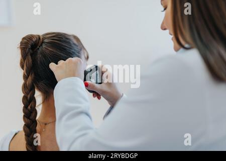 Médecin féminin expérimenté effectuant un examen médical approfondi à l'aide d'otoscope. Banque D'Images