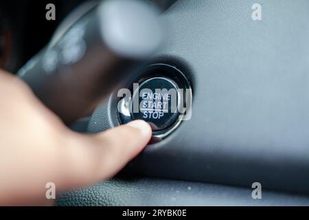 Doigt mâle appuyant sur le bouton START STOP du moteur Banque D'Images